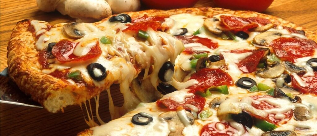 Imagem de uma pizza com bastante queijo derretido.